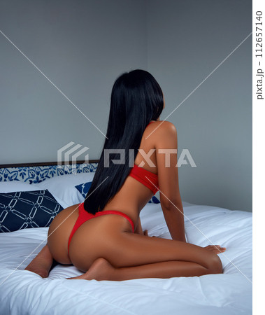 Sexy asian girl in red lingerie sitting on the bed 112657140