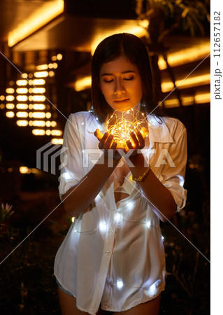Young asian woman in a white shirt posing at hotel territory Young asian woman in a white shirt posing at hotel territory 112657182