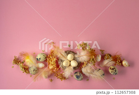 Easter composition with quail eggs, feathers, and dried flowers. 112657308