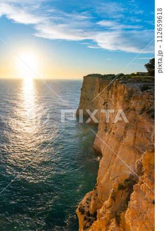 Natural caves and beach, Algarve Portugal. Rock cliff arches of Seven Hanging Valleys and turquoise sea water on coast of Portugal in Algarve region Natural caves and beach, Algarve Portugal. Rock cliff arches of Seven Hanging Valleys and turquoise sea water on coast of Portugal in Algarve region 112659618