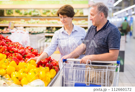 Mature couple husband and wife choose bell pepper in supermarket 112660172