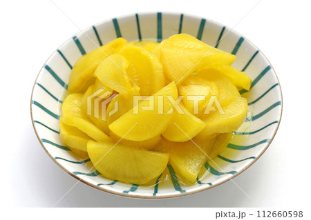 Sweet and tart slices of yellow pickled daikon, known as takuan in Japan and danmuji in Korea. Sweet and tart slices of yellow pickled daikon, known as takuan in Japan and danmuji in Korea. 112660598
