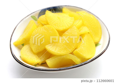 Sweet and tart slices of yellow pickled daikon, known as takuan in Japan and danmuji in Korea. Sweet and tart slices of yellow pickled daikon, known as takuan in Japan and danmuji in Korea. 112660601