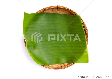 Banana leaves in bamboo weave plate on white background. Banana leaves in bamboo weave plate on white background. 112660967