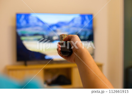 Hand holding TV remote control 112661915