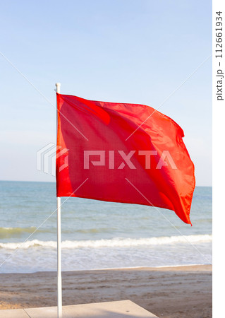 A red flag. Warning sign on the beach 112661934