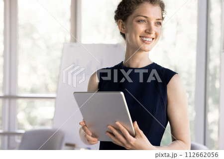 Young successful businesswoman standing in office with digital tablet Young successful businesswoman standing in office with digital tablet 112662056