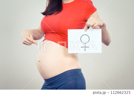 Pregnant woman holding card with female symbol. Expecting birth of girl. Extending family 112662325