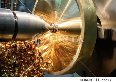 Closeup scene the lathe machine finish cut the brass parts and scrap material. Closeup scene the lathe machine finish cut the brass parts and scrap material. 112662451