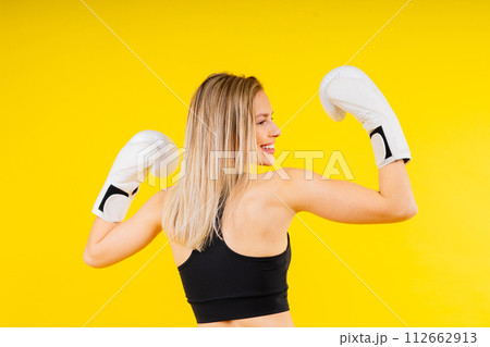 Female boxer hitting at a boxing studio. Woman in gloves training hard. Female boxer hitting at a boxing studio. Woman in gloves training hard. 112662913