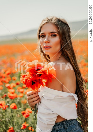 Woman poppies field. Side view of a happy woman with long hair in a poppy field and enjoying the beauty of nature in a warm summer day. Woman poppies field. Side view of a happy woman with long hair in a poppy field and enjoying the beauty of nature in a warm summer day. 112663190