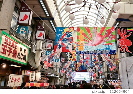 【兵庫・明石】魚の棚商店街。大漁旗が飾られた商店街、大勢の人で賑わい本場の明石焼も美味しかった。 112664904