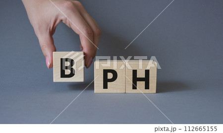 BPH - Benign Prostatic Hyperplasia symbol. Wooden cubes with word BPH. Businessman hand. Beautiful grey background. Medical and BPH concept. Copy space. BPH - Benign Prostatic Hyperplasia symbol. Wooden cubes with word BPH. Businessman hand. Beautiful grey background. Medical and BPH concept. Copy space. 112665155