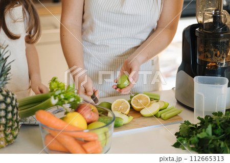 Middle selection of woman peel kiwi. Preparing for making juice in juicer. Homemade fresh and healthy beverage. Vegan Middle selection of woman peel kiwi. Preparing for making juice in juicer. Homemade fresh and healthy beverage. Vegan 112665313