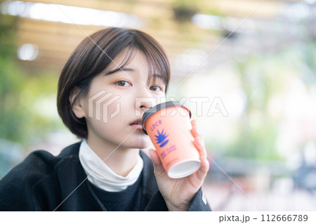 屋外でコーヒーを飲む女性 112666789