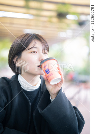 屋外でコーヒーを飲む女性 112666791