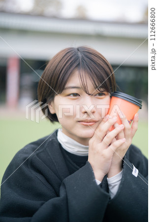 屋外でコーヒーを飲む女性 112666800