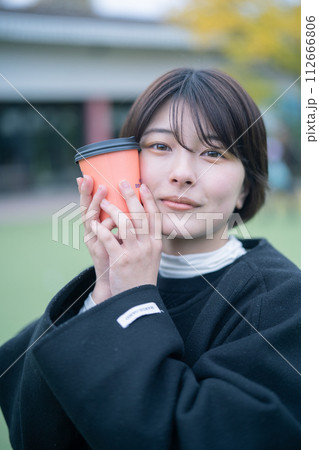 屋外でコーヒーを飲む女性 112666806