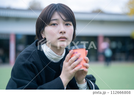 屋外でコーヒーを飲む女性 屋外でコーヒーを飲む女性 112666808