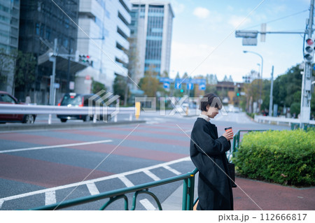 屋外でコーヒーを飲む女性 112666817