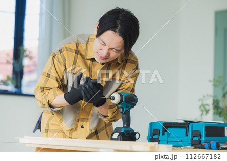 電動ドライバーで作業する若い男性　 112667182