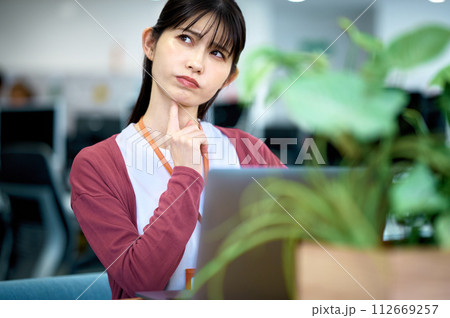 明るいオフィスでデスクワークをするビジネスウーマン 明るいオフィスでデスクワークをするビジネスウーマン 112669257
