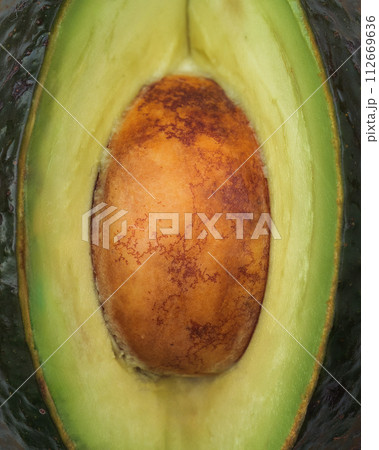 Close-up of an avocado's seed in its natural vibrant green setting Close-up of an avocado's seed in its natural vibrant green setting 112669636