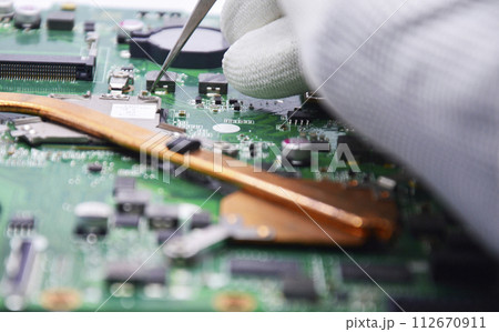 View from the top while a technician is fixing the motherboard. View from the top while a technician is fixing the motherboard. 112670911