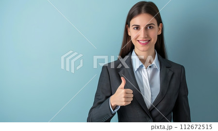 Portrait of a beautiful business woman showing thumbs up on blue background 112672515
