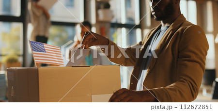 AI-generated content. A man and a woman are standing next to a box featuring the American flag. They appear to be in a voting setting, possibly participating in a patriotic event 112672851
