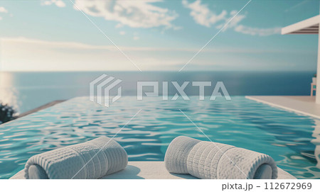 Sunbeds with towels by the pool with sea views. 112672969