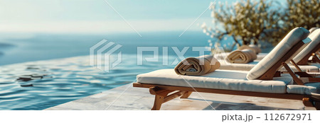 Sunbeds with towels by the pool with sea views. 112672971