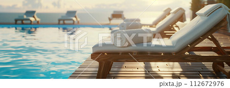 Sunbeds with towels by the pool with sea views. 112672976