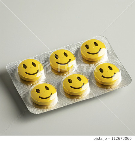 Blister full of yellow tablets decorated with smiley faces. Antidepressants in tablets. Fighting depression. Health concept 112673060