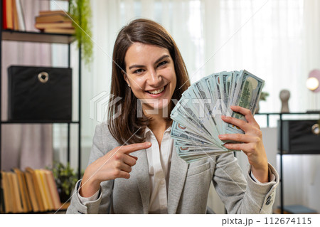 Smiling businesswoman counting cash money dollar checking salary enjoy richness at home office table Smiling businesswoman counting cash money dollar checking salary enjoy richness at home office table 112674115