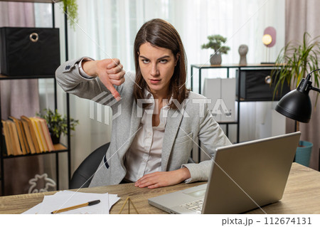 Business woman working on laptop at office showing thumbs down sign gesture dislike disapproval 112674131