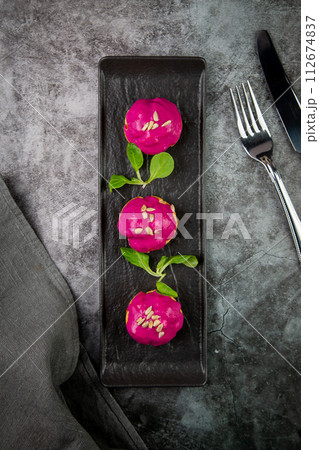 dessert of baked buns with raspberry topping and seed decorations, side view 112674837