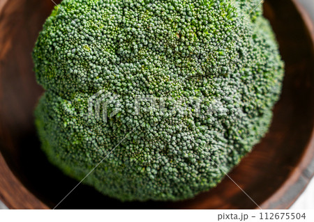 Pieces of fresh organic Broccoli in rustic bowl. Farm fresh vegetables. Green plant bio texture.  112675504