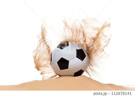 Classic sport football ball on sand pile over white background isolated. Sand splashing splatter by hitting soccer football ball attack and sand explode explosion. Classic sport football ball on sand pile over white background isolated. Sand splashing splatter by hitting soccer football ball attack and sand explode explosion. 112678141