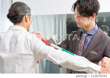 採寸をするスーツショップの店員 112678341