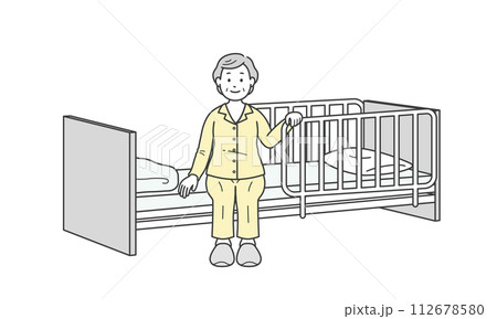 ベッドサイドに座るパジャマ姿の高齢女性と介護ベッド 112678580