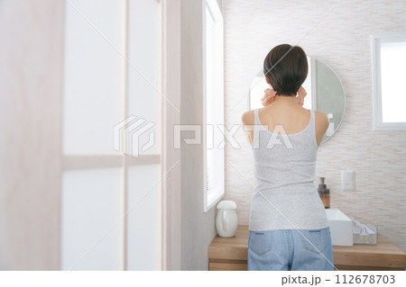 洗面所に立って洗顔をする女性の後ろ姿 112678703