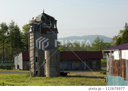廃屋になった農家とサイロ 112678977