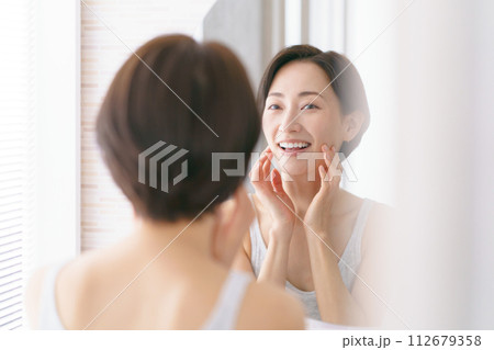 洗面所に立って洗顔をする女性の後ろ姿 112679358