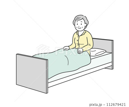 ベッドから起き上がるパジャマ姿で笑顔の高齢女性と介護ベッド 112679421