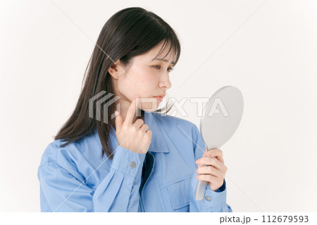 肌をチェックする作業服の女性 112679593