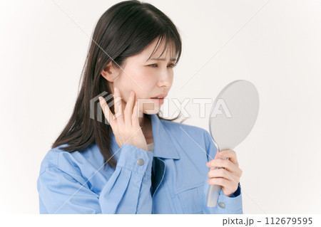 肌をチェックする作業服の女性 112679595