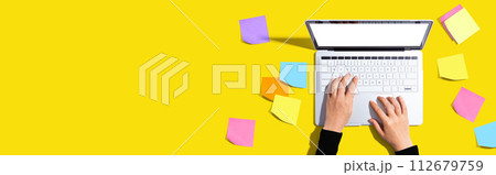 Laptop computer with many sticky notes 112679759
