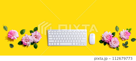 Computer keyboard and a mouse with pink roses 112679773
