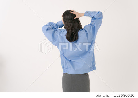 頭を抱える作業員の女性の後ろ姿 112680610